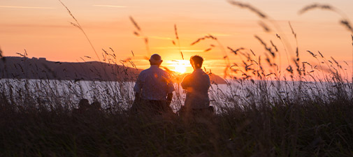 seniors watching sunset at the beach life insurance in retirement